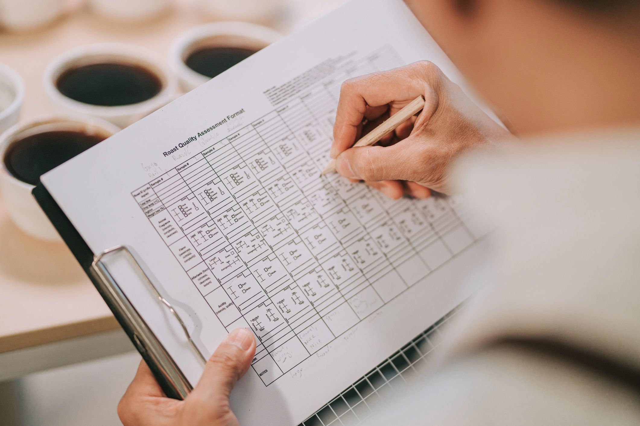 Person writing notes on a clipboard while reviewing material